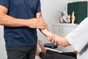Chiropractor treating elbow pain patient West Ryde Sydney