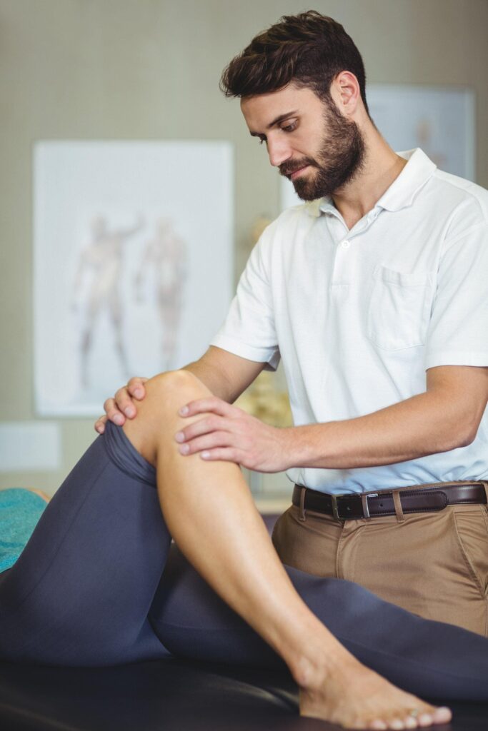 Chiropractor treating a patient's knee at TOP Chiropractic West Ryde
